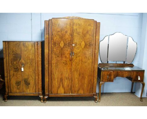 A 1940s burr walnut bedroom suite, comprising: a double door wardrobe, 116 x 55 x 194cm high, triptych mirror dressing table,