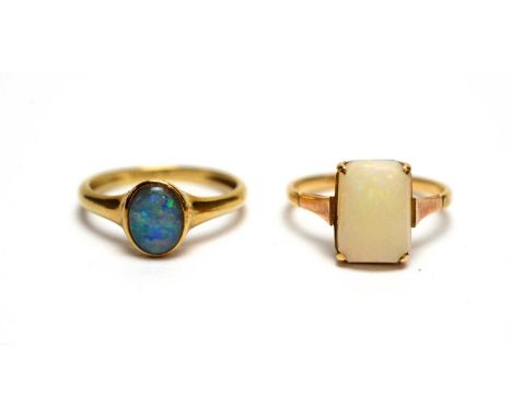 A white opal ring, the gold shank stamped '9ct', ring size O; and another opal ring, probably a doublet, on 9ct yellow gold s