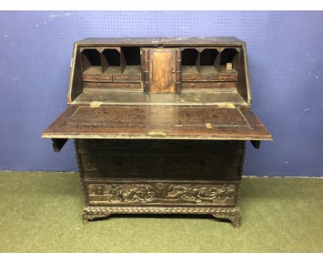 Central European oak bureau with 4 drawers, profusely carved with naive scenes of hunting, the fall flap depicting the hunt m