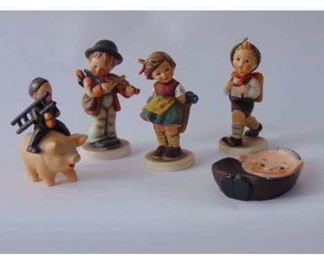 A collection of Goebel Hummel figures including a boy sweep holding a ladder and a clock riding on the back of a pig, a boy v