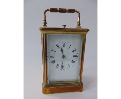 A good quality brass cased carriage clock with bevelled glazed panelled sides and front revealing a white enamel dial with bl