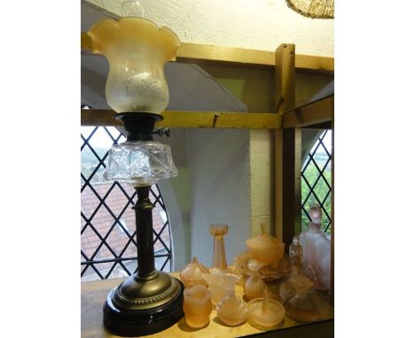 An oil lamp raised on a brass fluted column supporting a clear cut glass fount with a Duplex burner, clear glass chimney and 