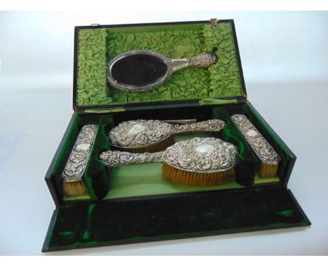 A cased Edwardian silver dressing set, Walker & Hall, Sheffield, 1902, comprising:  two hair brushes, a hand mirror and two c