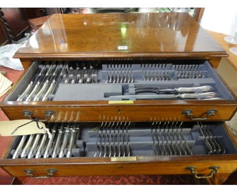 A walnut two drawer cabinet raised on four cabriole supports containing an extensive collection of silver plated flatware by 