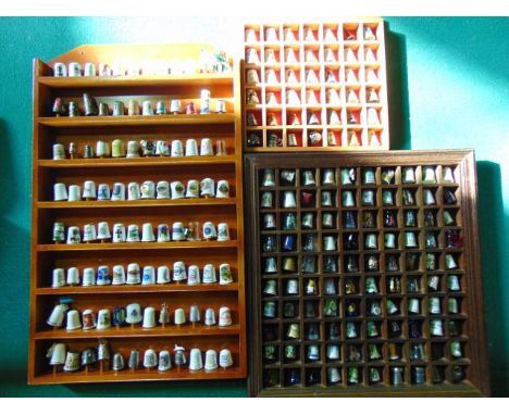 Three display racks containing an extensive collection of ceramic, glass, metal and other thimbles including Royal commemorat