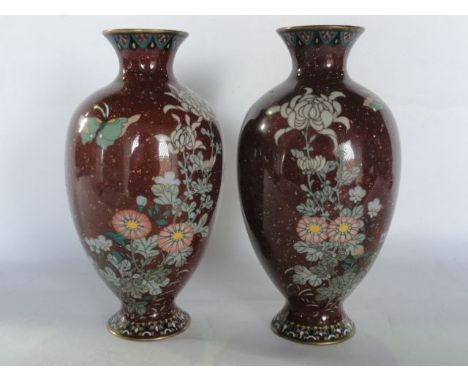 A pair of Chinese cloisonné enamel vases of baluster form with burgundy coloured ground and copper fleck detail, decorated in