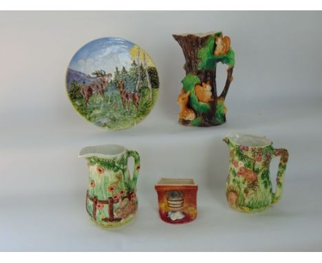 A large Hornsea jug modelled as a tree trunk with applied squirrels and deer together with two further relief moulded jugs fr