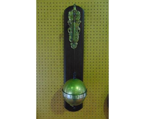 A falling ball wall mounted clock by Thwaites & Reed dated 1972 in the form of a brass globe with chased continental detail, 