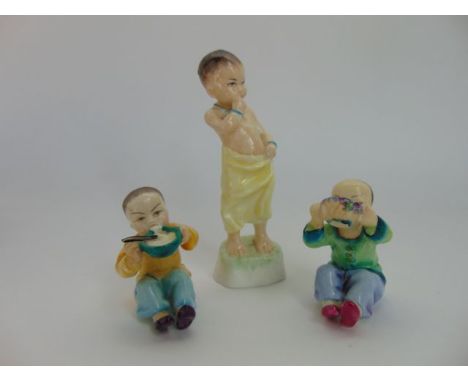 A set of three Royal Worcester figures by F G Doughty representing children of the world and comprising two versions of a chi