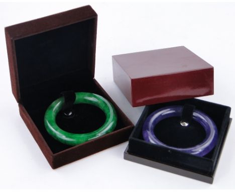 A Chinese green jade bangle,
diameter 3.2", boxed and another jade bangle, (2).