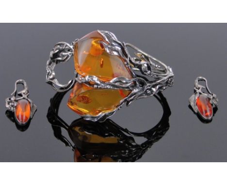 A modern amber set silver bangle,
and a pair of amber set earrings.