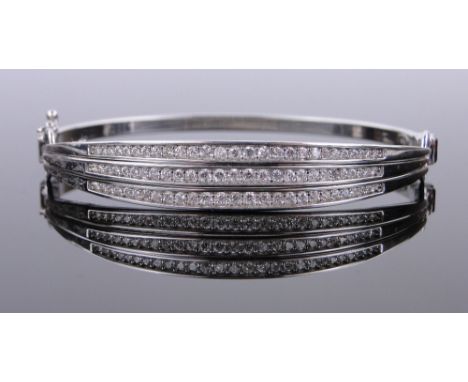 A modern 9ct white gold diamond set articulated bangle, 10.8g.
