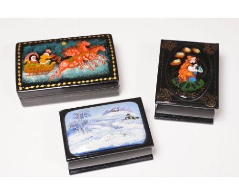 Three Russian papier-mache lacquered boxes, all with hand painted hinged lids including a man and woman on troika, largest 8.
