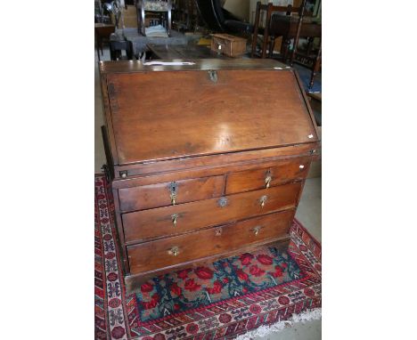 George III stained pine bureau, circa 1770, the front enclosing a fitted interior above two short and two long drawers on bra