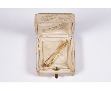A yellow metal bar brooch with pearl decoration set within vintage retailers box. 
