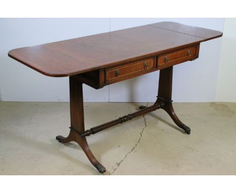 20th century mahogany drop leaf side table with two drawers with lion head handles, raised on  reeded legs and lion paw feet 