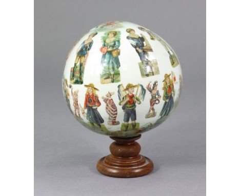 A 19TH CENTURY DECALCOMANIA GLOBE, decorated with numerous figures, animals, etc.; &amp; on a turned treen base, 7” diam.