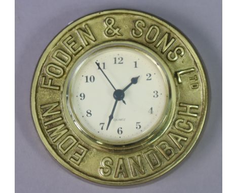 A small Quartz battery-operated wall clock in a brass frame inscribed “EDWIN FODEN &amp; SONS LTD. SANDBACH”, 14.5cm diam.