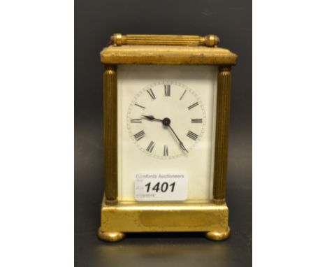 A French lacquered brass carriage clock, white rectangular enamel dial, Roman numerals, swing carry handle, column supports, 