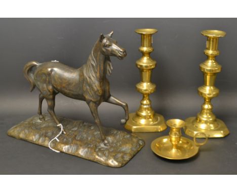 A bronzed model of a horse, 28cm high, 30cm long; a pair of brass candlesticks; a brass chamber stick (4)