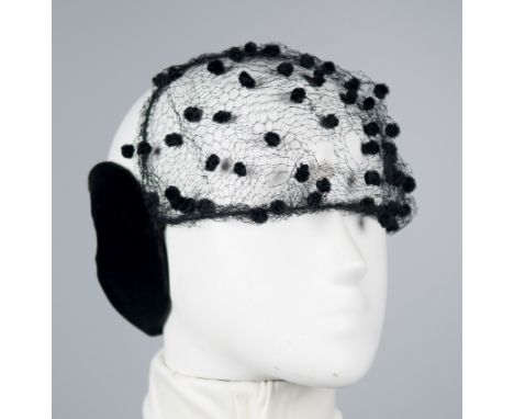 Antonia. 28, Av. Montaigne, Paris. Black velvet hat with black netting and small chenille tassels.The netting is torn.Vintage