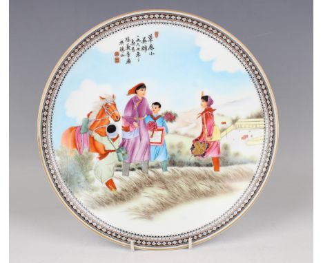 A Chinese famille rose porcelain circular dish, painted with a Cultural Revolution figural scene beneath lines of black text 