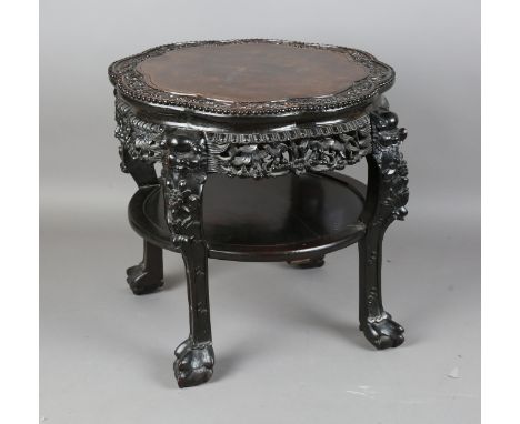 A Chinese hardwood stand, late Qing dynasty, the lobed circular top with carved prunus, precious object and beaded border, th