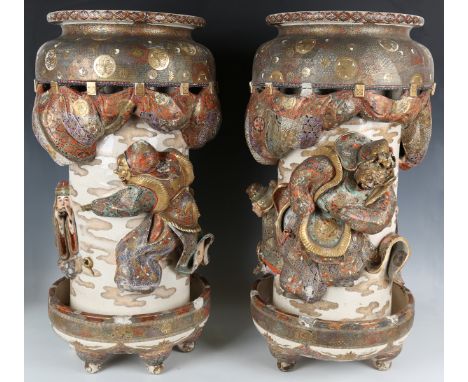 A pair of impressive Japanese Satsuma earthenware stick stands, Meiji period, each of cylindrical form, modelled in high reli