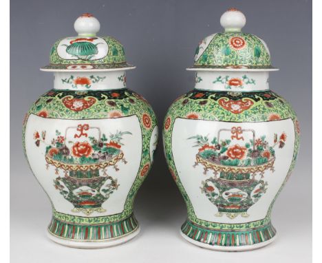 A pair of Chinese famille verte porcelain jars and covers, late Qing dynasty, each baluster body painted with a flower-charge