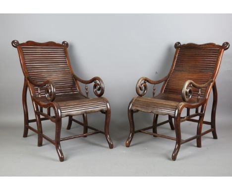 A pair of Chinese hardwood moon-gazing armchairs, 20th century, each with carved scroll top rail above simulated slatted back