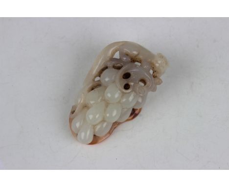 A Chinese jade pendant, carved and pierced with a squirrel surmounting a bunch of grapes, the stone of greyish pale celadon t