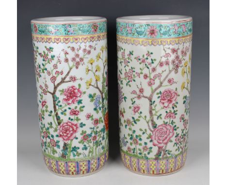 A pair of Chinese famille rose porcelain stick stands, 20th century, each cylindrical body painted with peony and prunus, hei