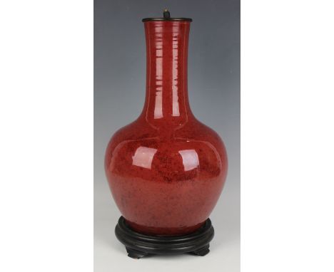 A Chinese sang-de-boeuf glazed porcelain bottle vase, Qing dynasty, the globular body and slightly flared narrow neck covered