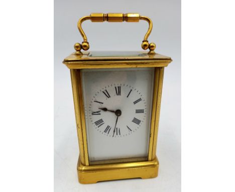A brass cased carriage clock with white enamelled dial, 11 cm high.