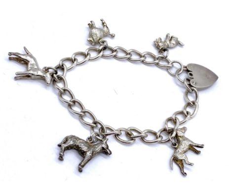 A vintage silver charm bracelet with assorted dog charms, 29g total weight. 