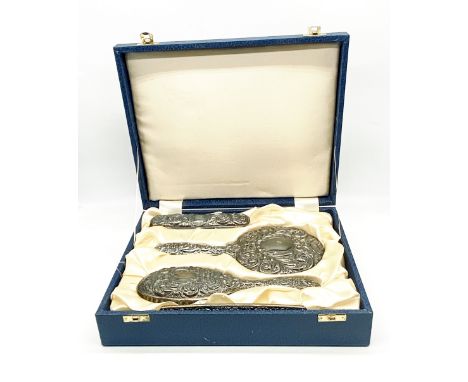 A cased Sterling silver dressing table set consisting of mirror, two brushes and a comb