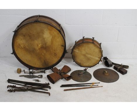 A collection of vintage percussion instruments, including two drums, cowbells, cymbals etc.