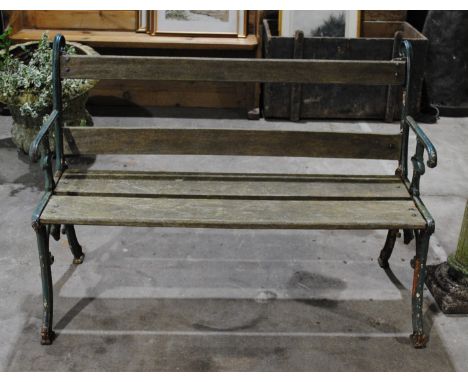 A Victorian Carron Foundry garden bench, with green painted cast iron ends and wooden slatted seat, marked 'Cn Co No 7 G' to 
