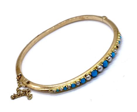 A Victorian gold turquoise and seed pearl hinged bangle set with alternating turquoise (one missing) cabochons and seed pearl