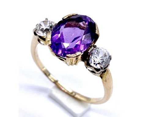 A gold dress ring tests as 9ct set with central amethyst flanked by cubic zirconia, size R 1/2, 3.2g total weight.