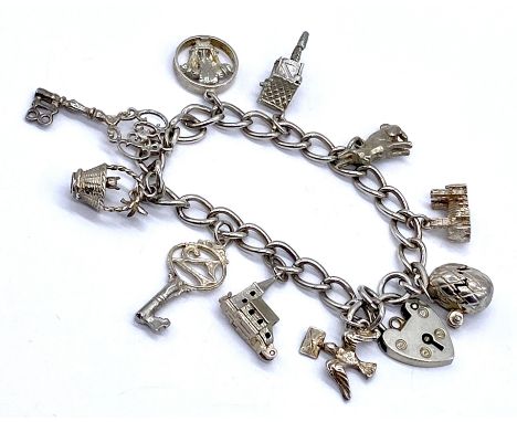 A vintage silver charm bracelet with assorted charms including an egg revealing a chick, 30g total weight.