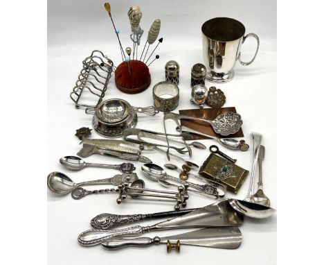 A collection of assorted silver plated items to include sardine tongs, two silver handled shoe horns and a button hook etc.