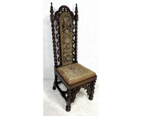 A heavily carved hall chair with tapestry style upholstery, repeating leaf motif and turned legs