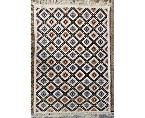 A woollen carpet with allover geometric pattern on an ivory field. L.230 W.195cm. 