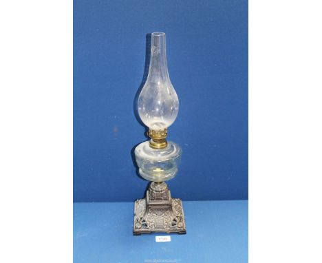 A metal square based oil lamp with clear glass reservoir and chimney, 20 1/2" tall (chimney has a piece missing at base).