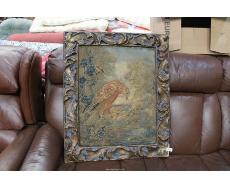 An antique tapestry of a bird of prey looking into a pond fed by a waterfall in an ornate frame, some loose pieces, 27" wide 