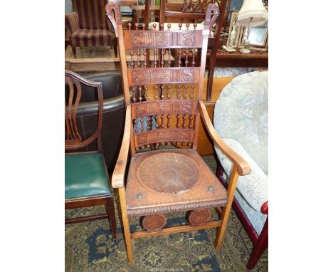 An uncommon design arts and crafts, open armed Satinwood framed Elbow Chair having a brass studded embossed patterned leather