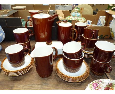 A Poole part coffee set in brown glaze to include nine cups, eleven saucers, coffee pot, hot water pot, cream jug etc.
