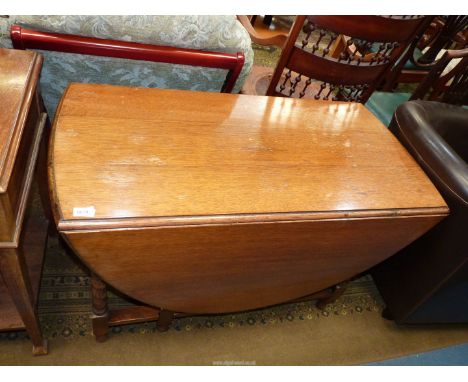 A medium shade Oak gate leg drop-leaf Dining Table having twist supports, 42 1/8" x 21 1/2" extending to an oval 59" and 27 1