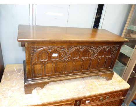 A dark Oak Coffer Bach standing on bracket feet, the front carved representing three Gothic arch typed windows, 37" wide x 14